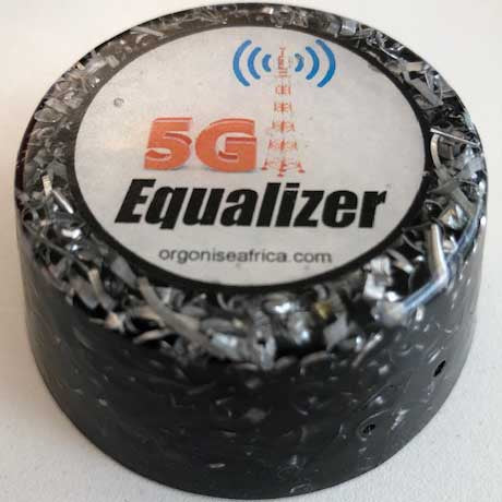 Black cylindrical orgonite device with white circular label reading '5G Equalizer' and website address, sitting on white surface