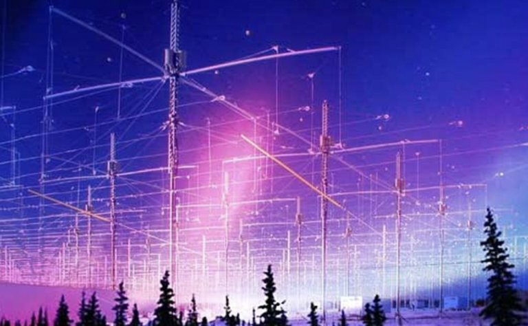Large radio antenna array with metal towers and cables against purple-blue aurora sky, silhouetted evergreen trees in foreground