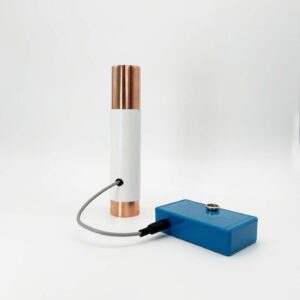 White cylindrical tube with copper-colored metal ends connected by gray cable to blue rectangular control box on white background