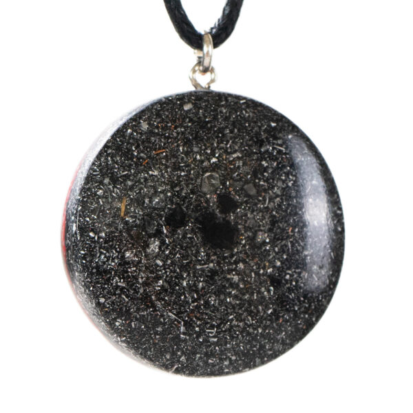 Black circular pendant with sparkly metallic flecks and central dark cavity, hanging from black cord with silver bail