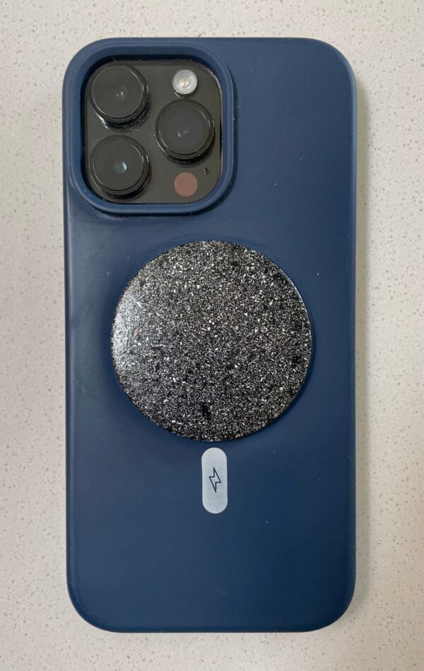 Blue silicone phone case with triple camera cutout, circular black glittery disc attached, white lightning bolt symbol below