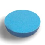 Round blue orgonite disc with textured surface, viewed from above at slight angle on white background