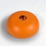 Orange dome-shaped orgonite candle holder with copper-colored metal insert viewed from above on white background
