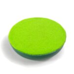 Green circular orgonite disc with bright lime green surface and darker green edge, viewed from above on white background