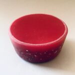 towerbuster orgonite cilíndrico rojo con patrón decorativo en el borde inferior, visto desde arriba en ángulo ligero
