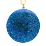 Round blue glittery pendant with sparkly surface and dark flecks, suspended from yellow cord with silver metal clasp