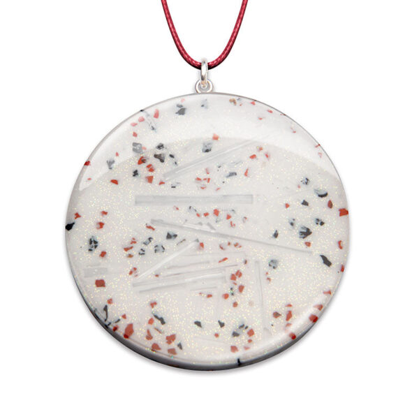 Round white orgonite pendant with red/black speckles and clear crystal points, hanging from red cord against white background