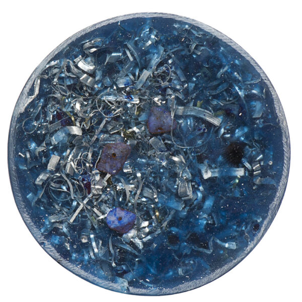 Round blue orgonite towerbuster with lapis lazuli stones and metal shavings embedded in translucent resin, viewed from above