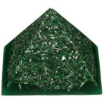 Green orgonite pyramid with translucent resin containing curled green metal shavings, viewed from front angle on white background