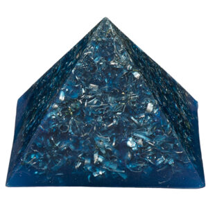 Blue orgonite pyramid with metallic shavings and crystals embedded throughout, photographed against white background