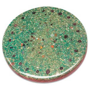 Round green orgonite charging plate with embedded crystals, stones, and metallic flecks viewed from above on white background
