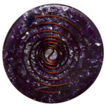 Lila runde orgonite-Scheibe mit eingebetteten Kristallsplittern, Kupferspiralen und zentralem Yin-Yang-Symbol, von oben betrachtet