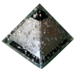 Rautenförmige orgonite-Pyramide mit silberner Metalloberfläche links, dunkelbraunem Bereich rechts, schwarzen shungite-Stücken