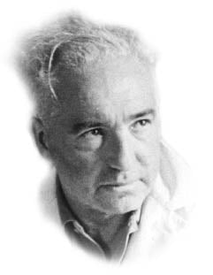 Black and white portrait photograph of an elderly man with wavy gray hair and a gentle expression