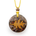 Round pendant with yellow sun symbol and mixed materials on yellow cord with brown and amber beads